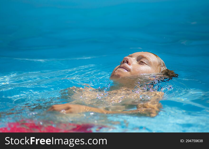 Young Boy Swimming In The Pool