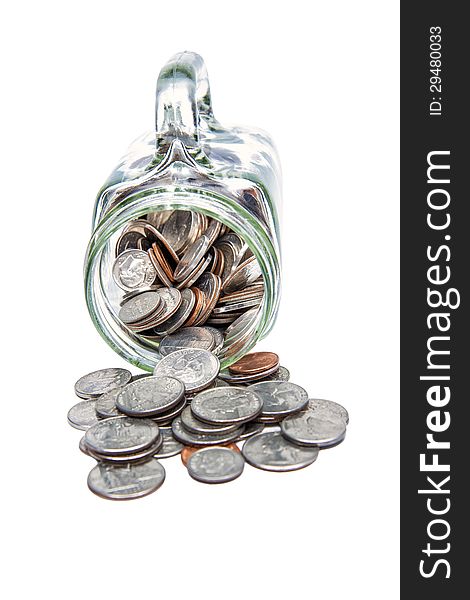 Vertical shot of many coins spilling out of a glass jar and isolated on a white background. Vertical shot of many coins spilling out of a glass jar and isolated on a white background.