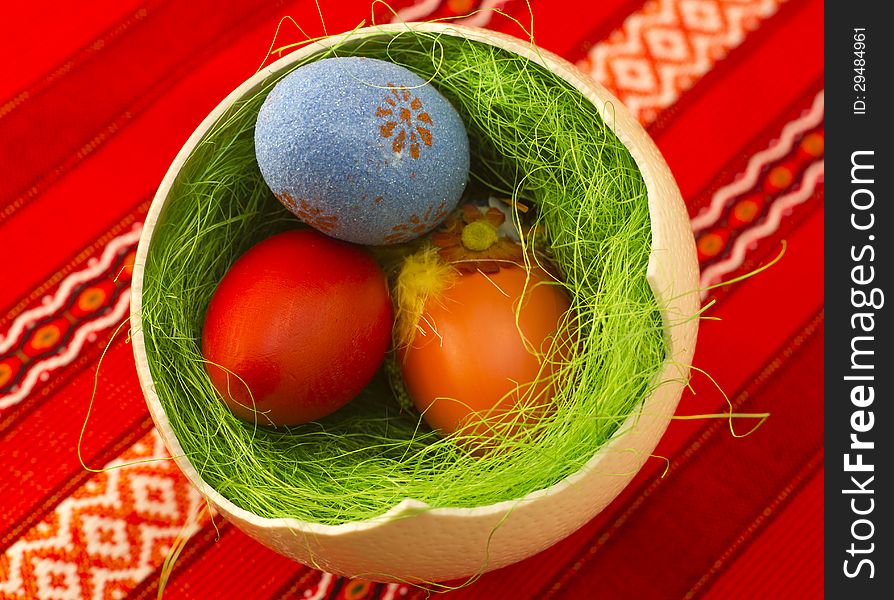 Colored Easter eggs in one big ostrich egg with grass.