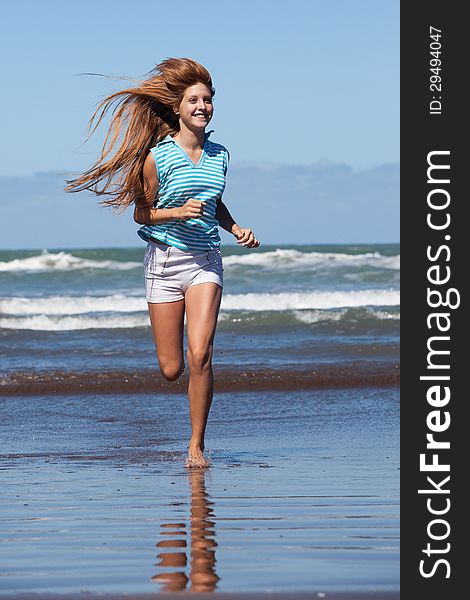 Happy young woman running at the beach. Happy young woman running at the beach