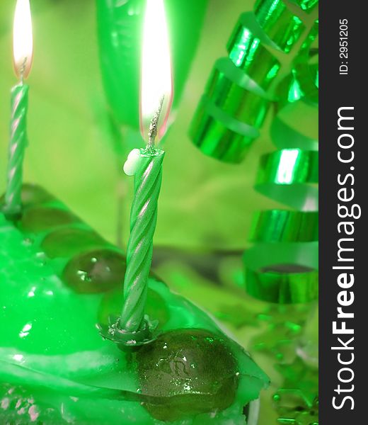 Cake and candles on green background