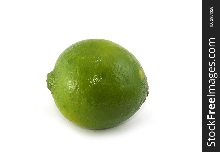 One green lime liyng on the white background. One green lime liyng on the white background