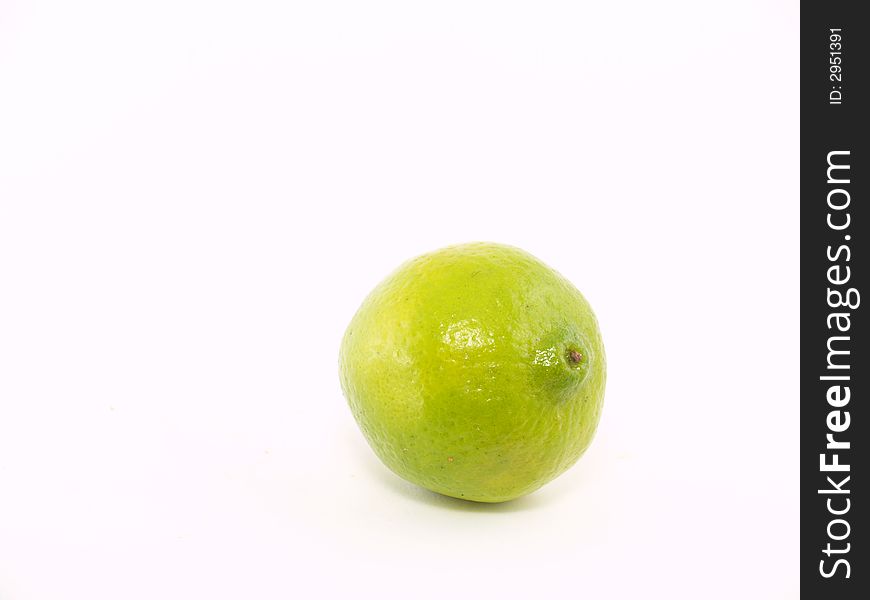 One green lime liyng on the white background. One green lime liyng on the white background