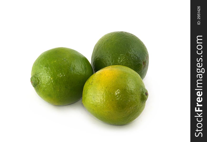 Three green limes liyng on the white background. Three green limes liyng on the white background