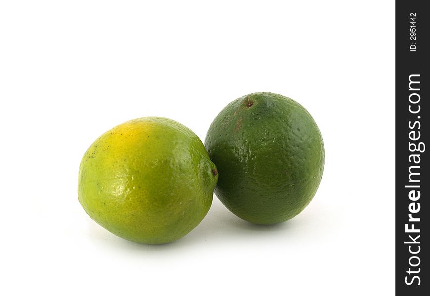 Two green lime liyng on the white background. Two green lime liyng on the white background