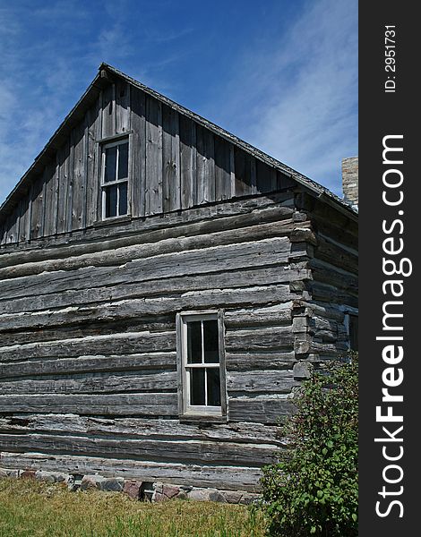 A settler's log cabin - side wall with blue sky.