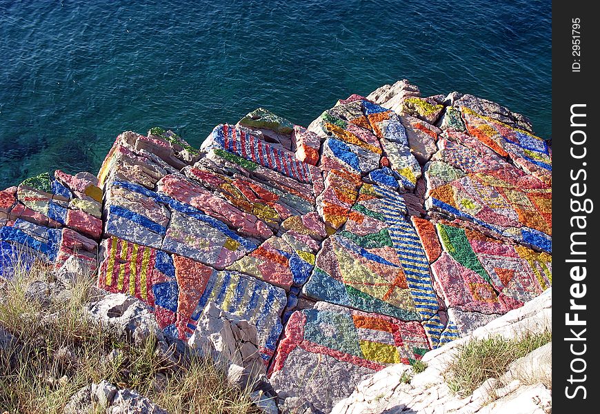 Colorful painted rock and blue sea