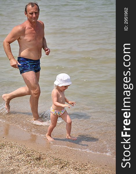 Granddad with girl on a beach