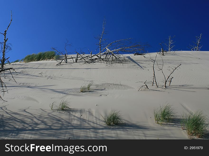 Sand-drift in the desert over blue sky