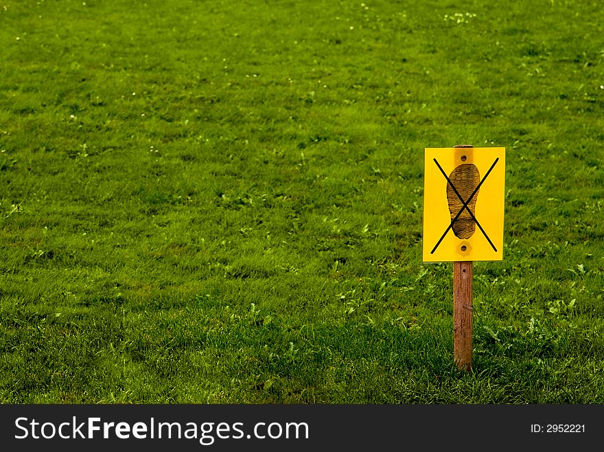 "Do not enter" yellow sign on grass background. "Do not enter" yellow sign on grass background