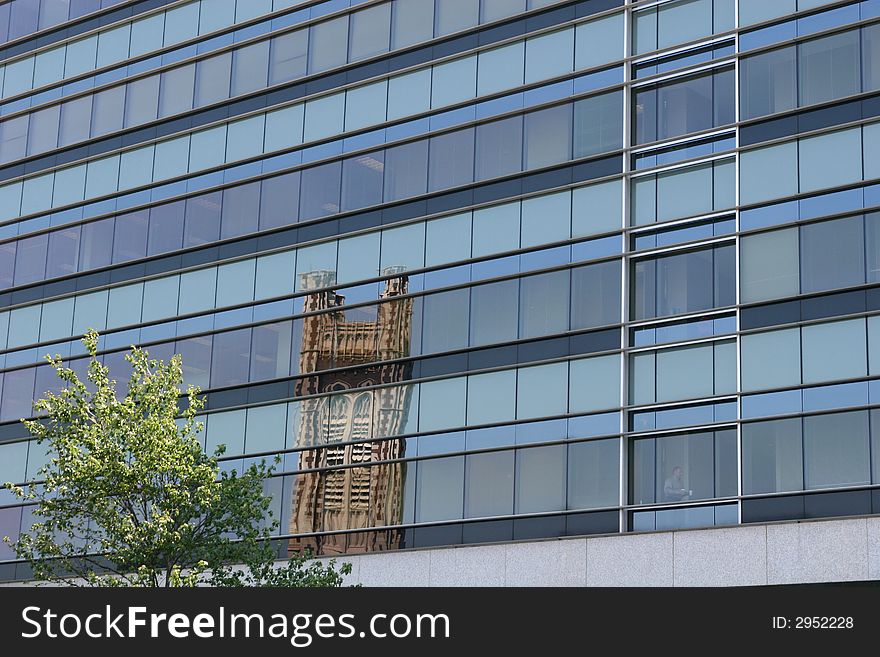 A blue glass office building with a church tower reflected. A blue glass office building with a church tower reflected