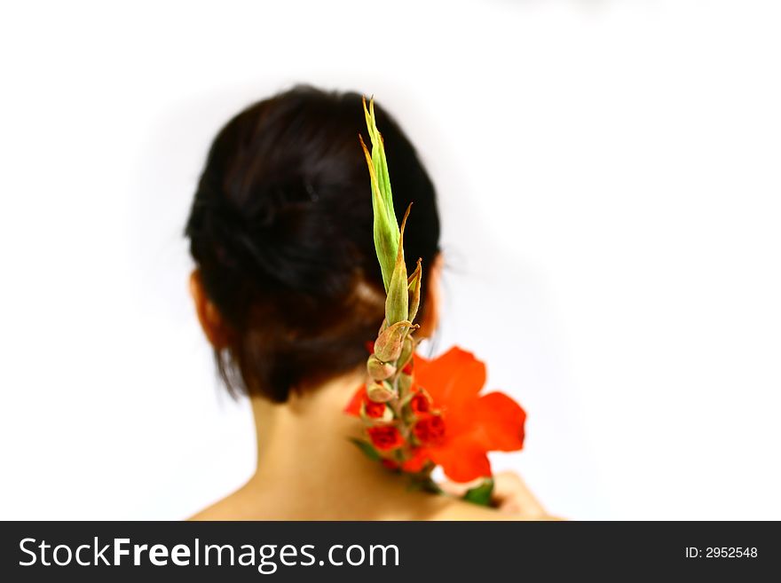 Back of a young woman with a flower and black hair. Back of a young woman with a flower and black hair