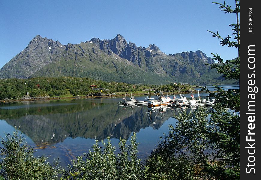 Picturesque small marina under the mountains. reflection of yachts in the water. Picturesque small marina under the mountains. reflection of yachts in the water.