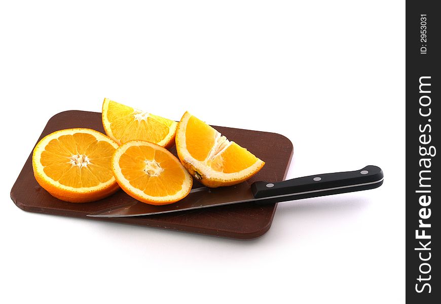 Slices of an orange and knife on a chopping board. Isolate on white