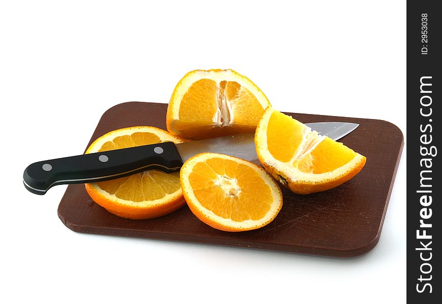 Slices of an orange and knife on a chopping board. Isolate on white