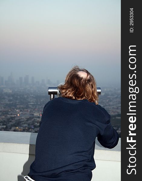 Man looking at LA through Coin Operated Binoculars