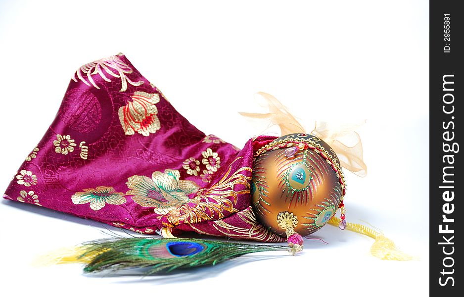 Decorated egg peacock feather and bag still life