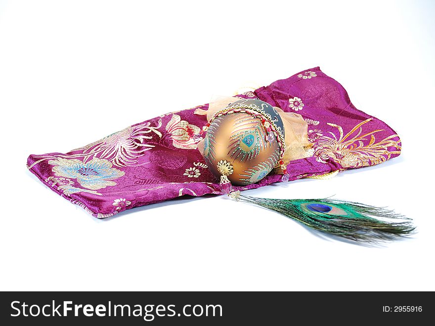 Decorated egg peacock feather and bag still life