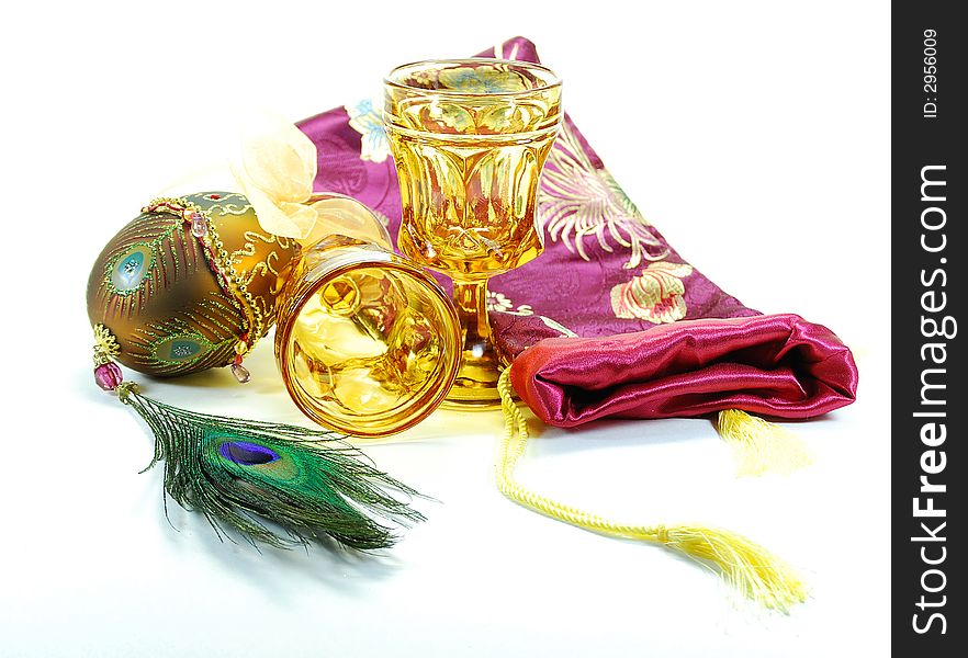 Decorated egg peacock feather drinking glasses and bag still life