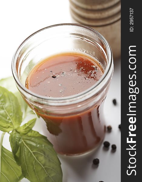 Tomato juice with pepper, pepperbox  and sweet green basil on white background