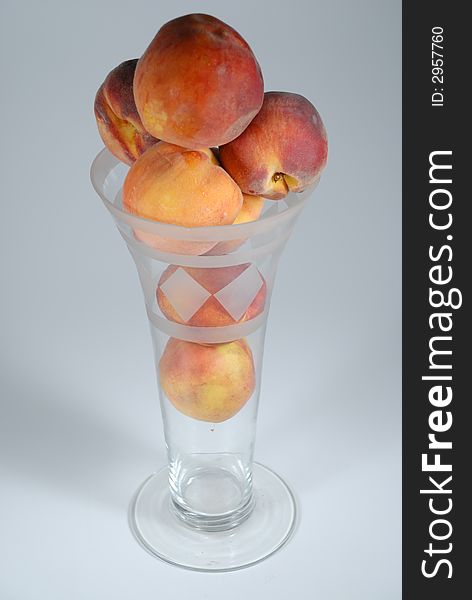 Peach stacked in a vase and isolated