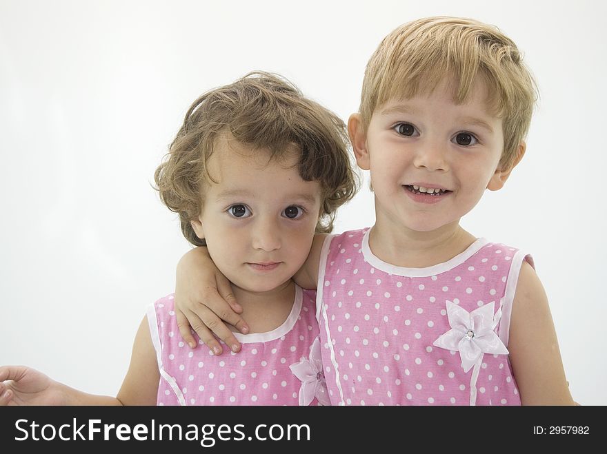 Twins sisters posing in pink dresses with dots
