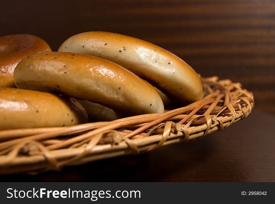 Appetizing bagels on wicker plate at the table