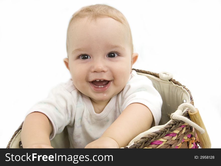 Cute and happy baby boy sitting in a basket