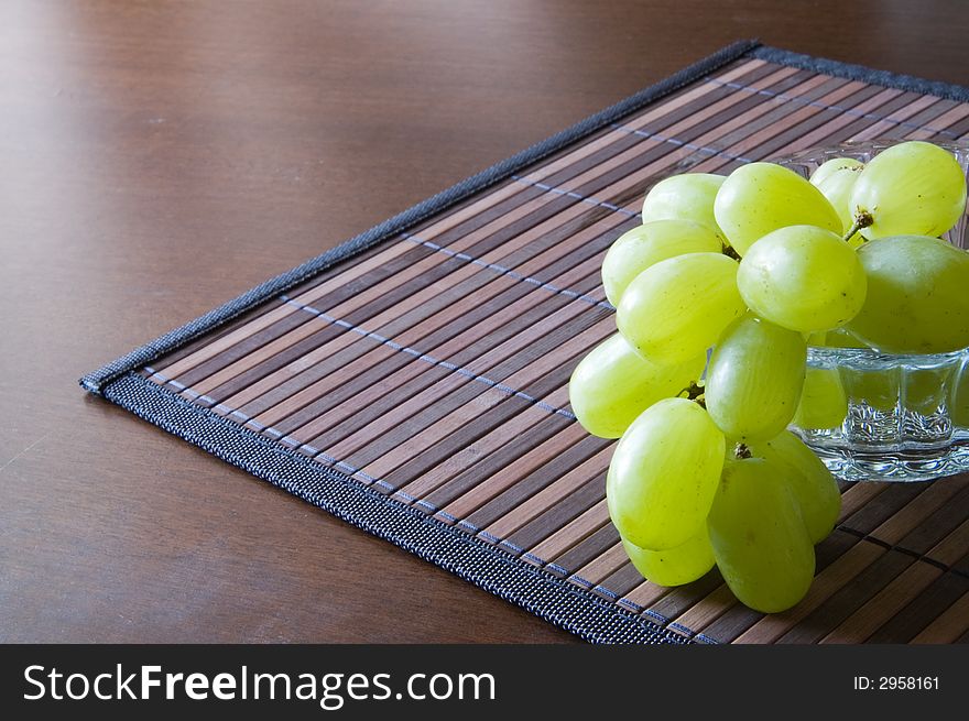 Juicy green grape on a bamboo napkin. Juicy green grape on a bamboo napkin