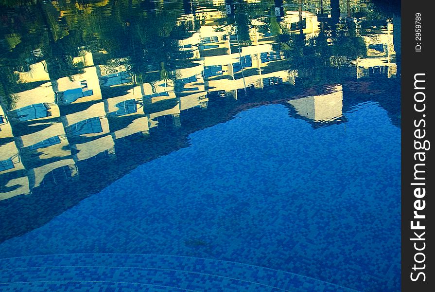 a resort hotel by a beach with large  free format pool .

a reflection of a modern five star hotel