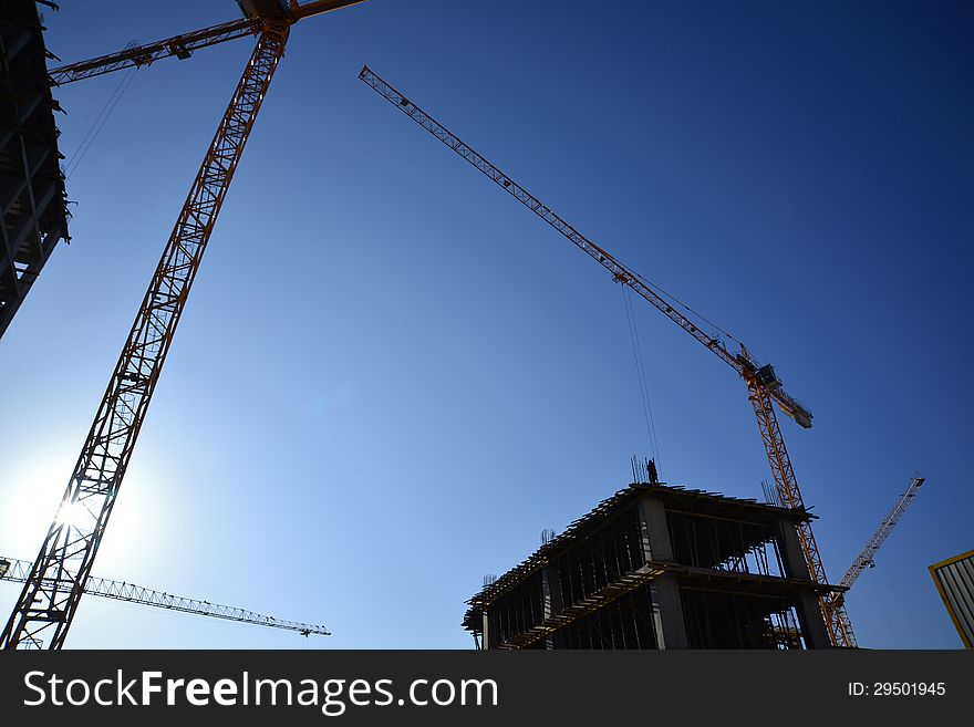 High construction crane and building and blue sky. High construction crane and building and blue sky