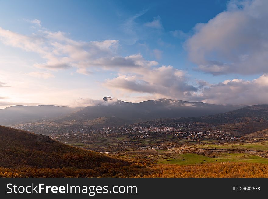 View of a village, green fields and meadows from the top of a mountain on a sunny autumn day