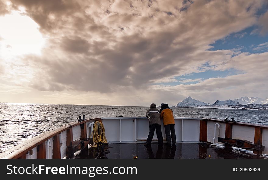Two men in the prow of the ship sailing in the Norwegian fiords