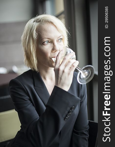 Blonde Woman With Beautiful Blue Eyes Drinking Glass Of White Wi