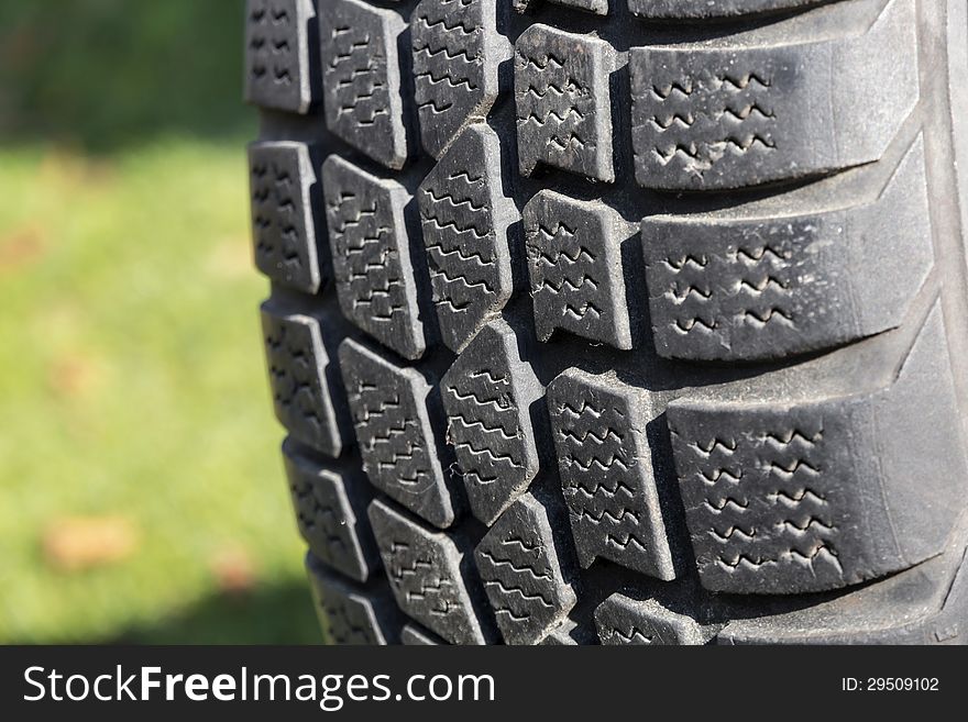 Old car tire on green background. Old car tire on green background.