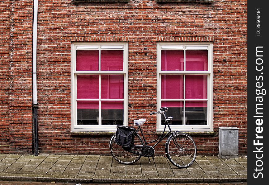 A classic bicycle against brick wall at streets of Middelburg, Netherlands. A classic bicycle against brick wall at streets of Middelburg, Netherlands.