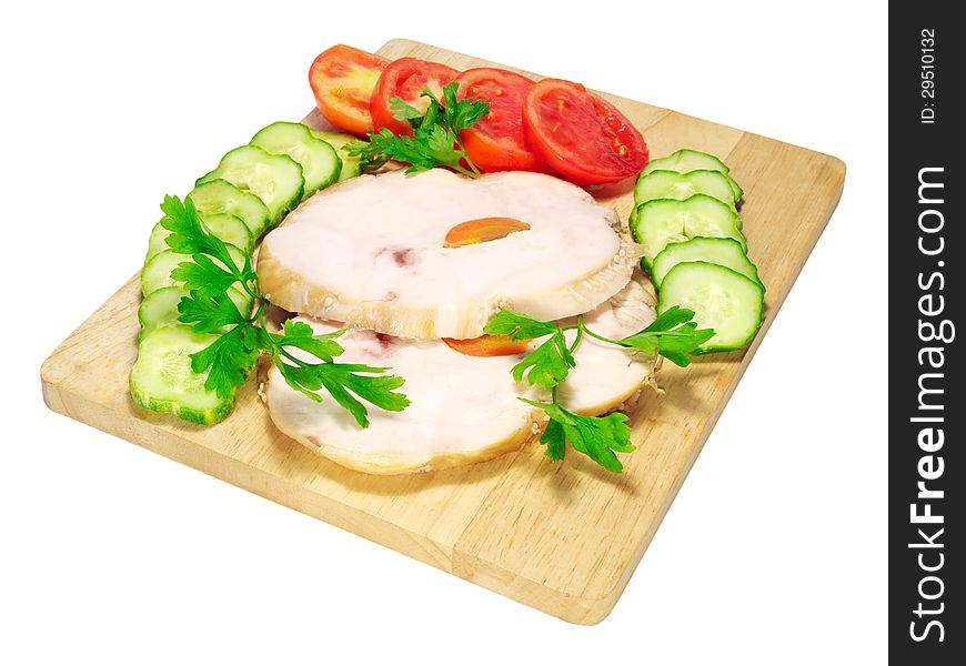 Two pieces of ham with tomatoes and cucumbers on a chopping board isolated on white background. Two pieces of ham with tomatoes and cucumbers on a chopping board isolated on white background