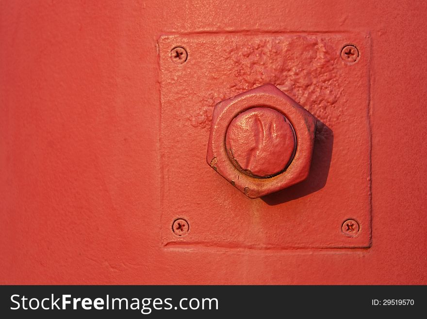 Nut and bolt fixed on red post with screws