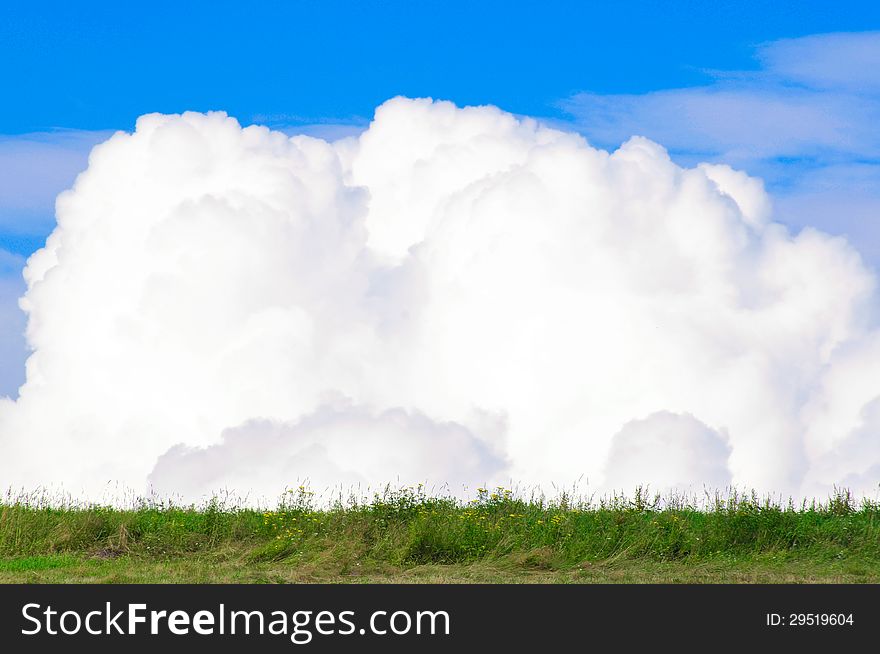 Beautiful clouds in the blue sky on the background of meadows. Beautiful clouds in the blue sky on the background of meadows