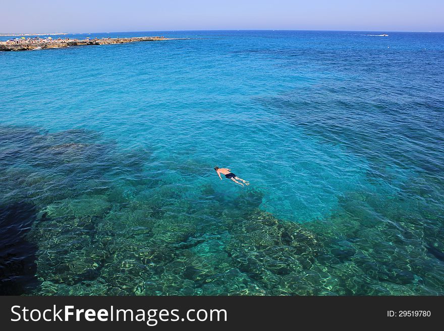 A holiday immersed in the blue sea of Sardinia. A man do snorkeling in quiet sea. A holiday immersed in the blue sea of Sardinia. A man do snorkeling in quiet sea.