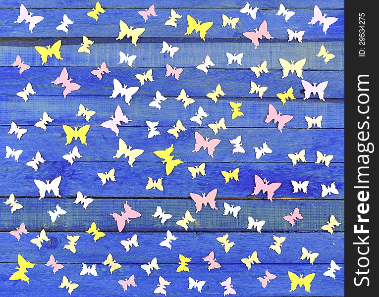 Butterfly paper cutouts on the blue wooden background. Butterfly paper cutouts on the blue wooden background