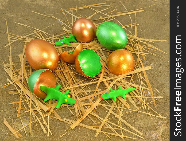 Gold and green eggshells with tiny crocodiles made of clay. Gold and green eggshells with tiny crocodiles made of clay