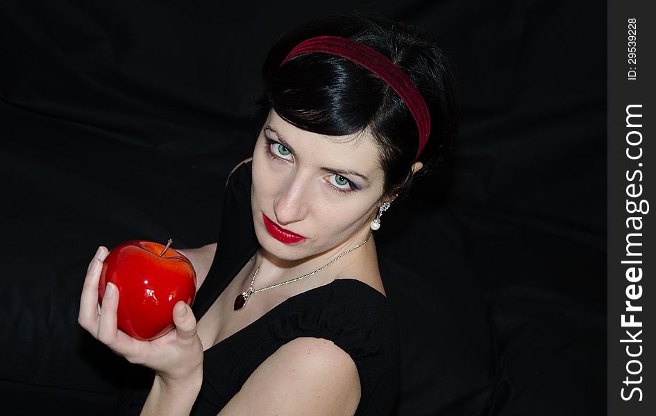 Portrait of brunette woman with red apple.