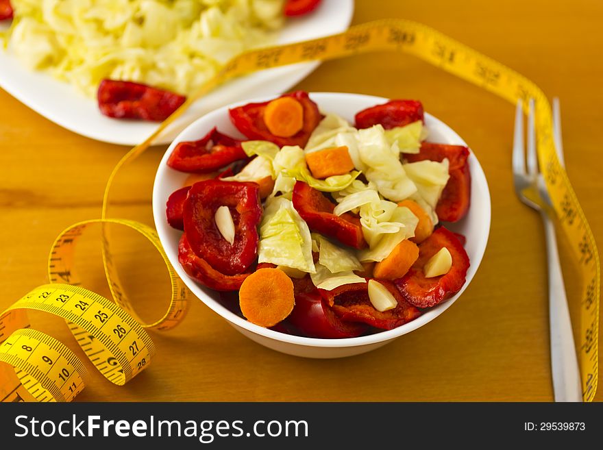 Bowl and plate with vegetables on table. Bowl and plate with vegetables on table.