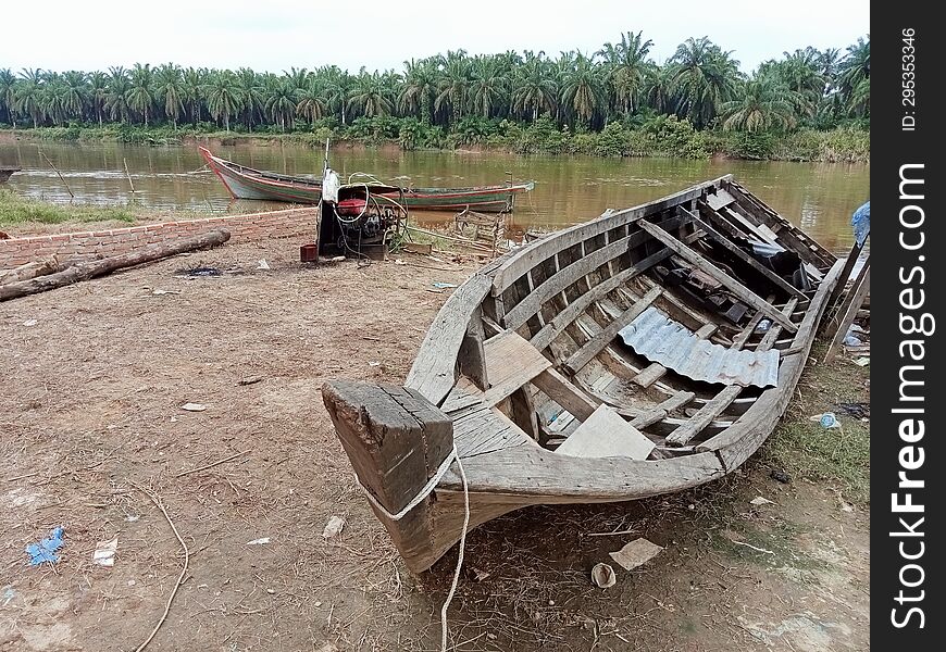 Old fishing boats are stranded on the riverbank and are no longer used. Old fishing boats are stranded on the riverbank and are no longer used
