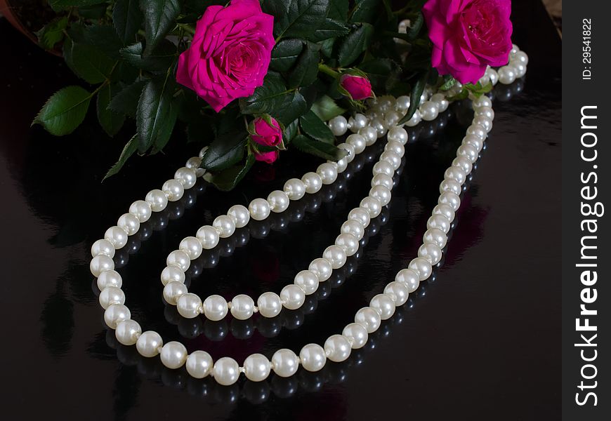 Pearl necklace and bouquet of roses