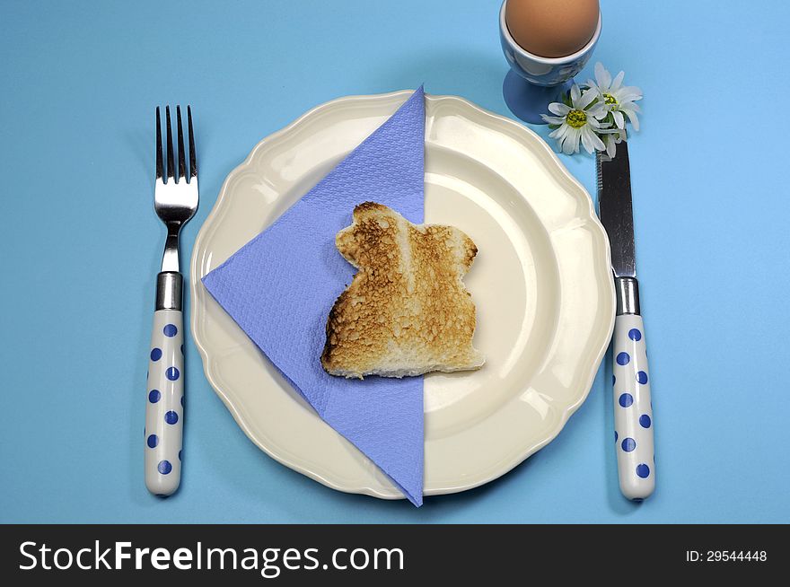 Blue theme Happy Easter breakfast table with bunny rabbit toast and egg.