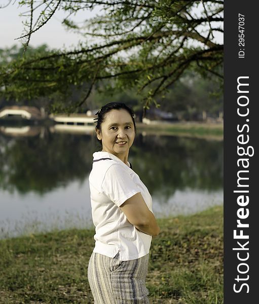Happy asian woman posing against a background of nature