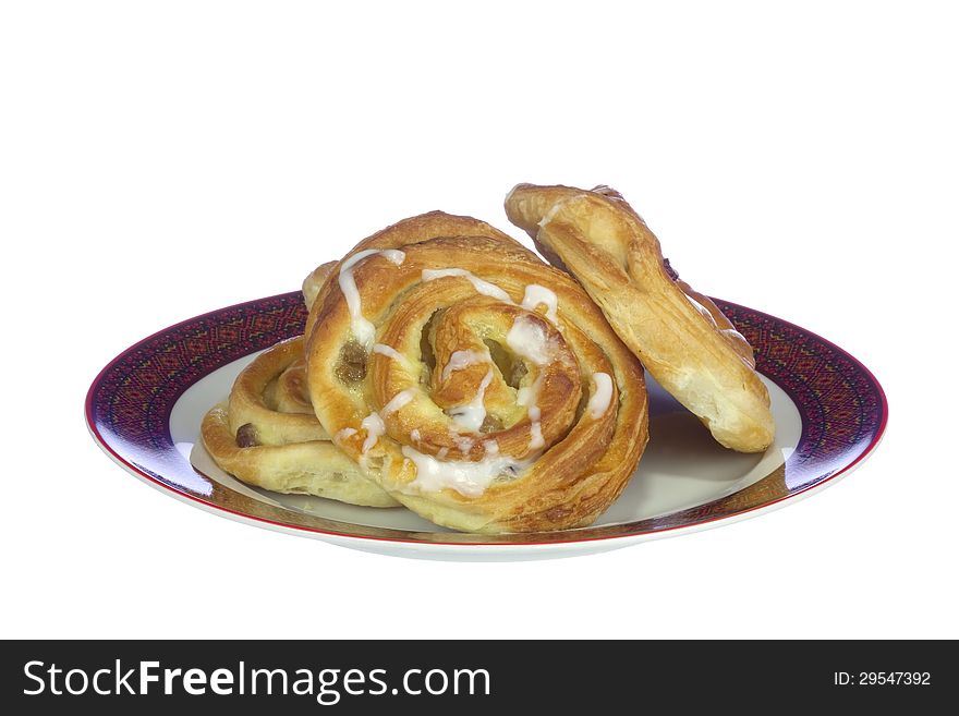 Buns with cream and raisins on the plate, isolated on white background