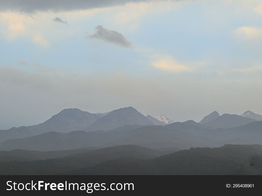 Mountains of Trans-Ili Alatau on an early cloudy morning in the morning fog during sunrise